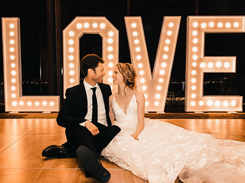 Bridge and groom in front of "LOVE" lighting